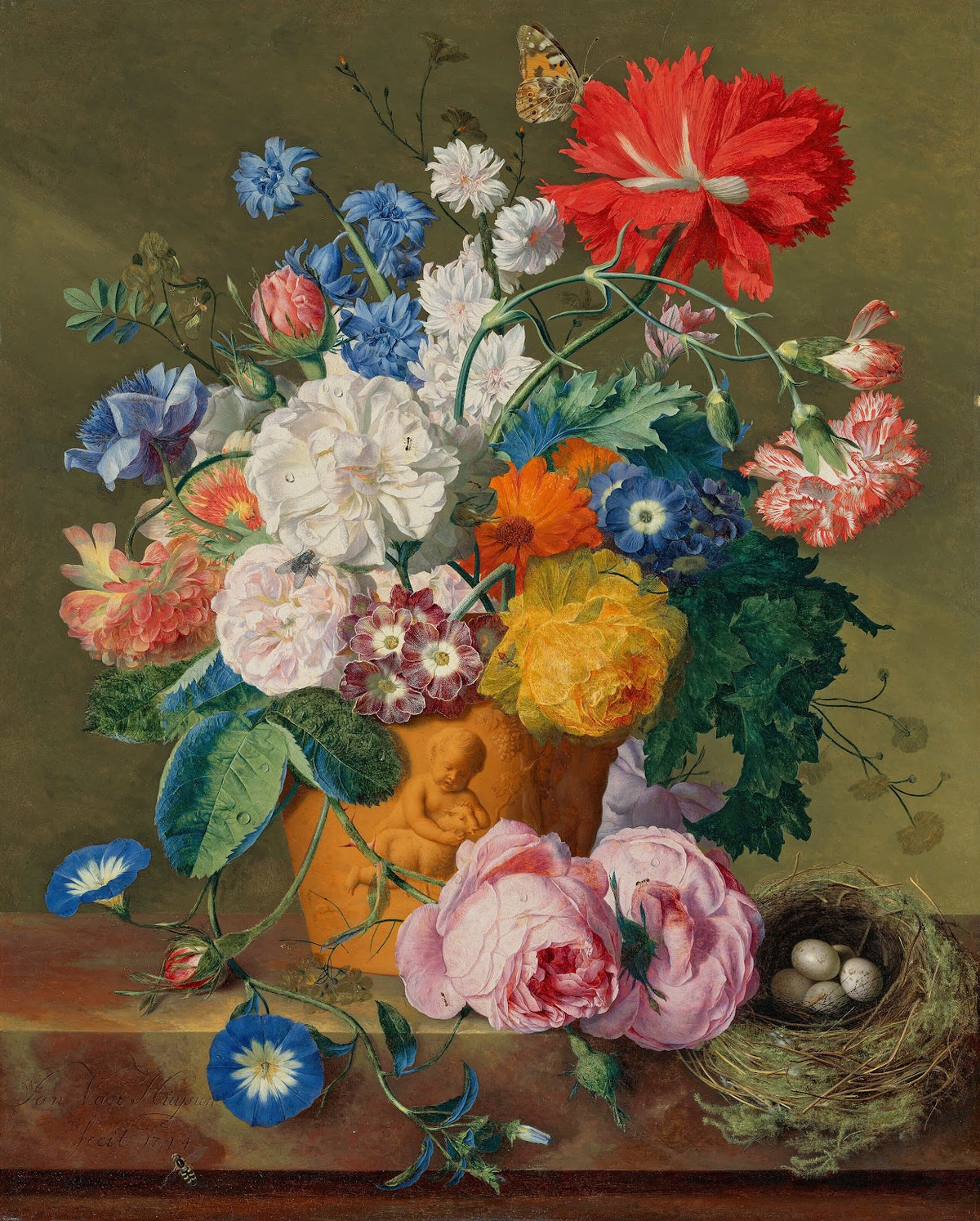 Roses and other flowers in a terracotta vase with a birds nest on a marble ledge