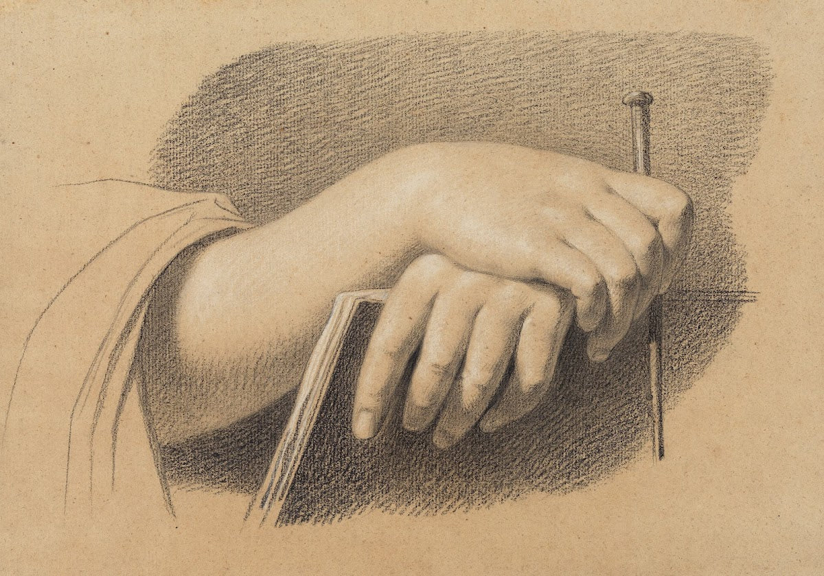 Die Hände eines Zeichners mit Stift über dem Zeichenheft verschränkt